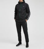 Person wearing a black tracksuit with white stripes on a light gray background