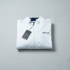 Folded white jacket with Tommy Hilfiger logo on a gray background