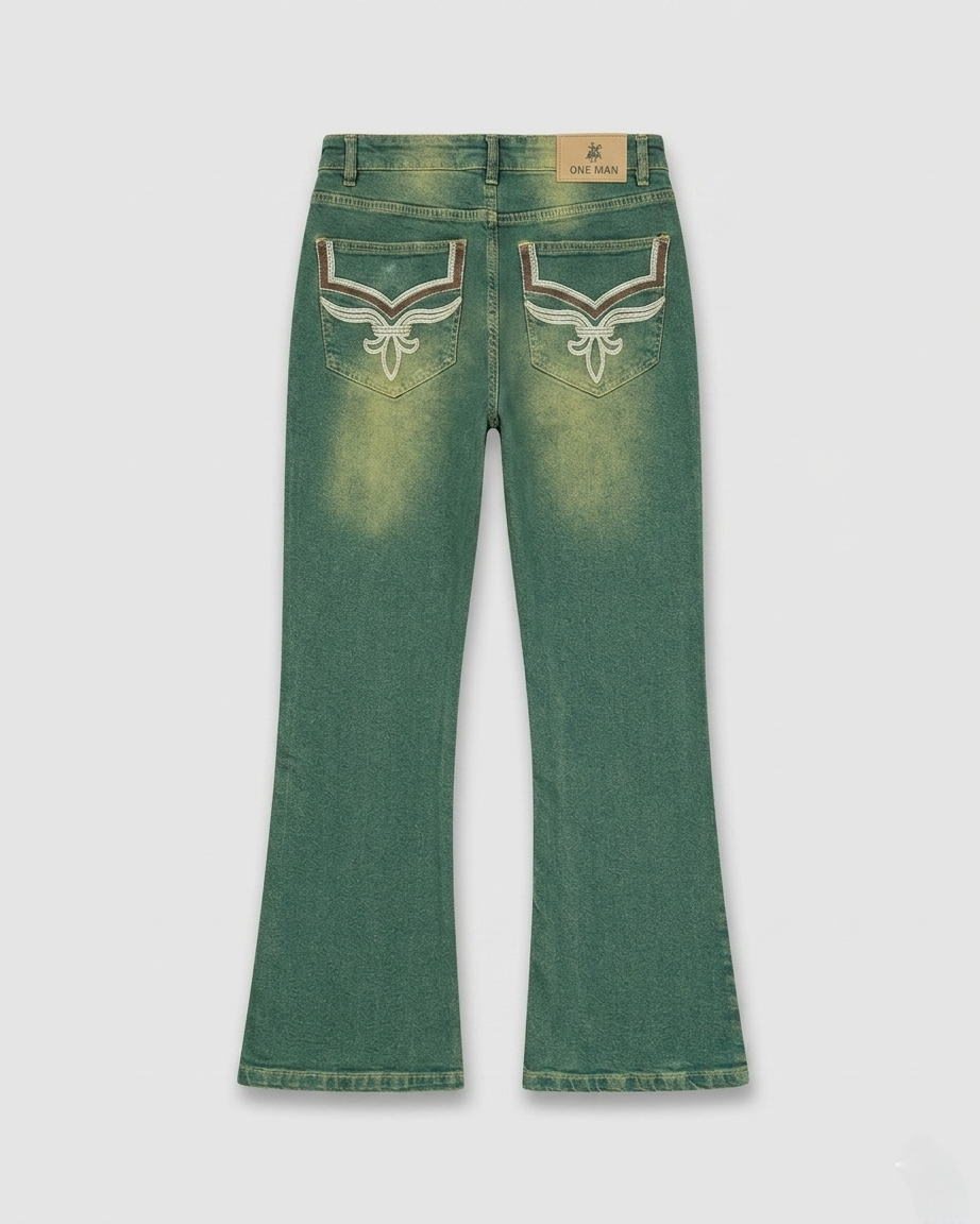 Green denim jeans with decorative stitching on a light gray background