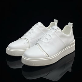 White sneakers with a brand logo on a white box against a brick wall background