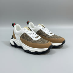 Pair of brown and white sneakers with a pattern on a green surface.