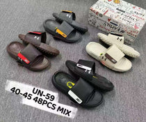 Collection of Under Armour slides on a gray surface with a branded box in the background.