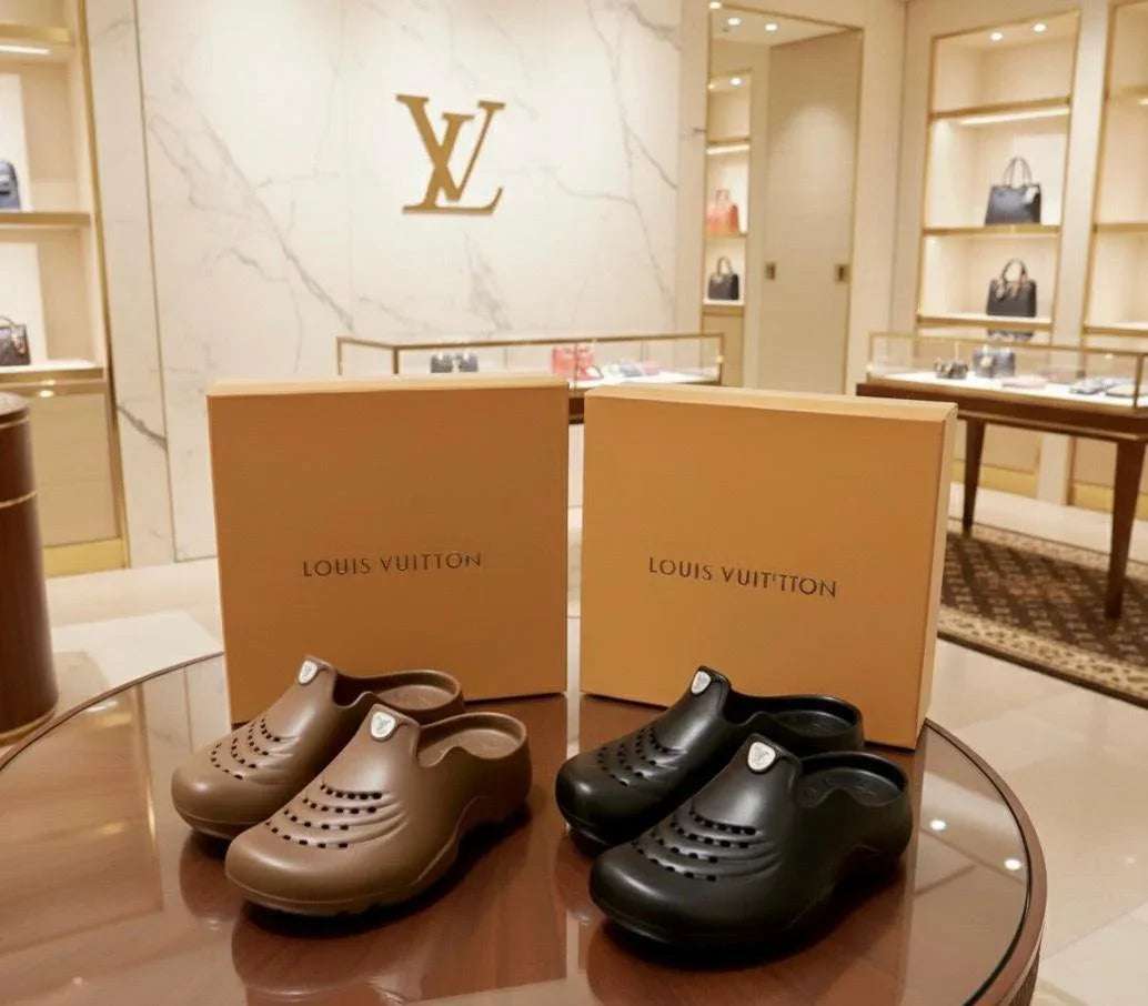 Louis Vuitton clogs and boxes on a glass table with a store interior in the background Main image