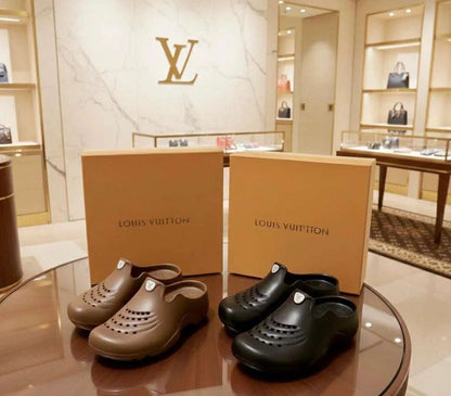 Louis Vuitton clogs and boxes on a glass table with a store interior in the background