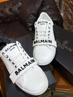 White Balmain sneakers on a black box with a blurred background