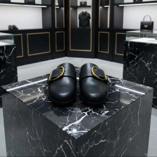 Black shoes on a marble platform with a high-end store interior in the background.