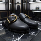 Black shoes with gold buckles on a marble surface, with 'UNIVERSES' branding above.