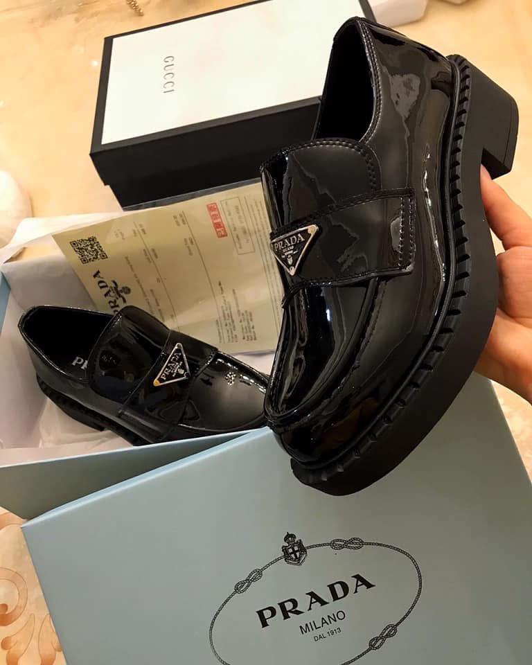 Black Prada shoes with box and receipt on a light background