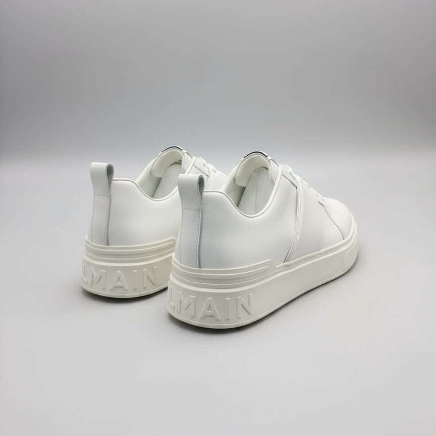 White sneakers with brand logo on a gray background