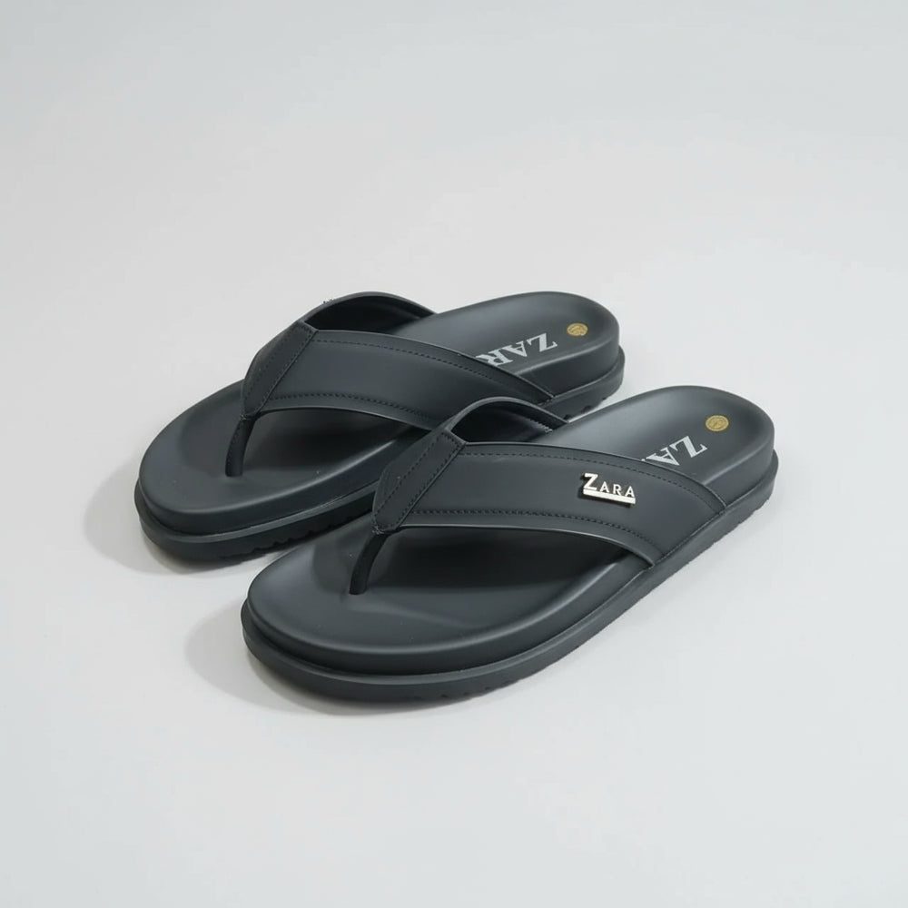 Pair of black Zara sandals on a wooden surface