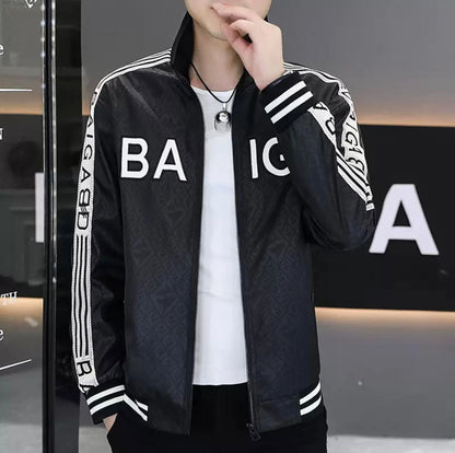 Black jacket with white lettering worn by a person, against a blurred indoor background.