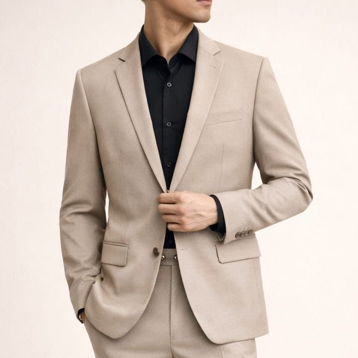 Man wearing a beige suit with black shoes on a plain background