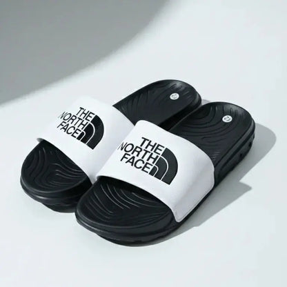 Black and white slides with The North Face logo on a light gray background