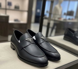 Black loafers with Prada logo on a display table
