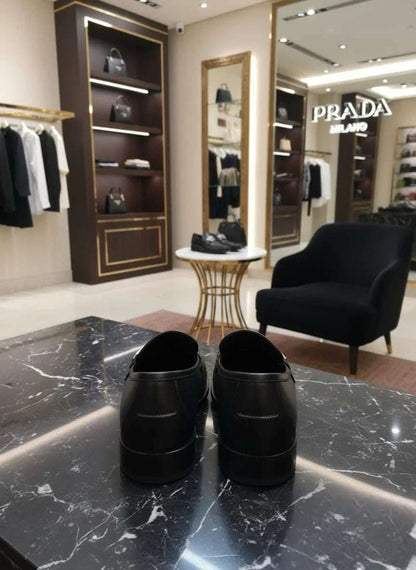 Black shoes on a marble surface with a Prada store in the background