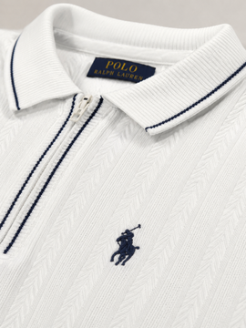 Close-up of a white Polo Ralph Lauren zip-up polo shirt with navy blue piping and the signature embroidered polo player logo on the chest.