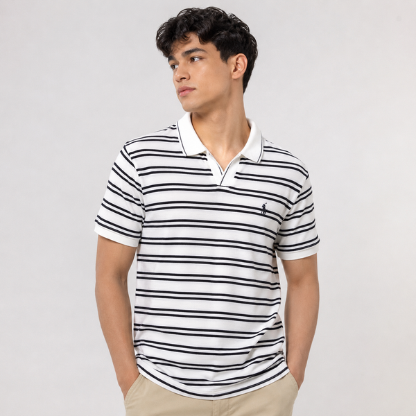 A man wearing a white short-sleeve polo shirt with thin black horizontal stripes and a small black embroidered polo player logo on the chest, paired with khaki pants, against a light gray studio background.